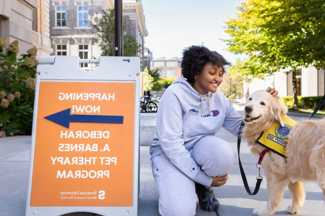 Students with pet therapy dog outside at the Barnes Center.